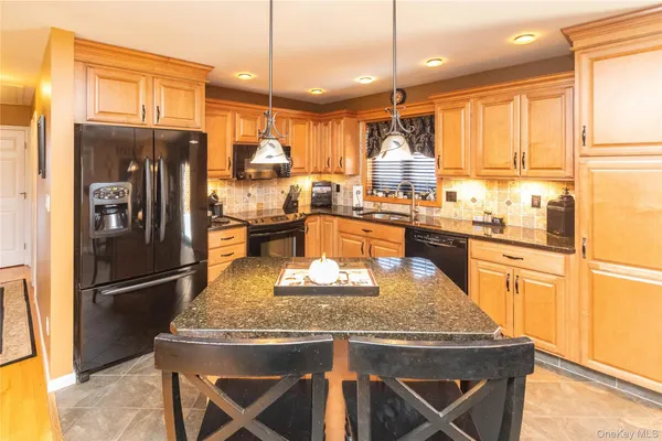 a kitchen with stainless steel appliances granite countertop a stove refrigerator and a sink