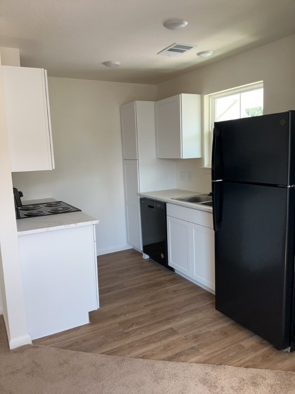 2002 West 2nd Street, Unit 1002 Taylor, TX 76574 - Photo 6 of 15 a kitchen with a refrigerator and a stove