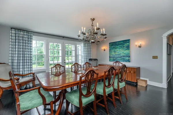 a dining room with furniture a chandelier and wooden floor