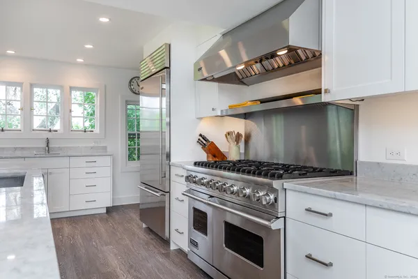 a kitchen with white cabinets and appliances