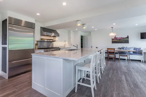 a kitchen with stainless steel appliances a microwave a stove a table and chairs