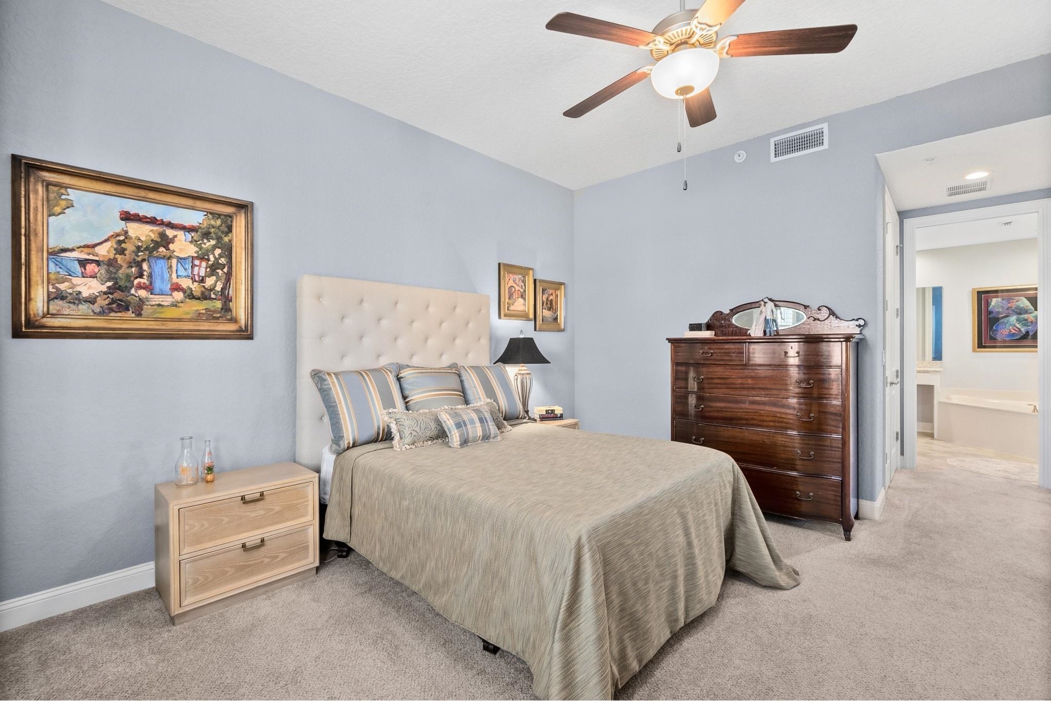 131 Laterra Links Circle, Unit 101 St. Augustine, FL 32092 - Photo 30 of 60 a bedroom with a bed and a chandelier