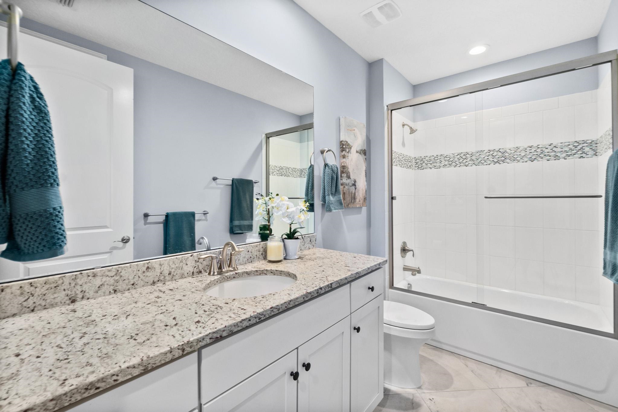 131 Laterra Links Circle, Unit 101 St. Augustine, FL 32092 - Photo 35 of 60 a bathroom with a granite countertop sink mirror vanity and toilet