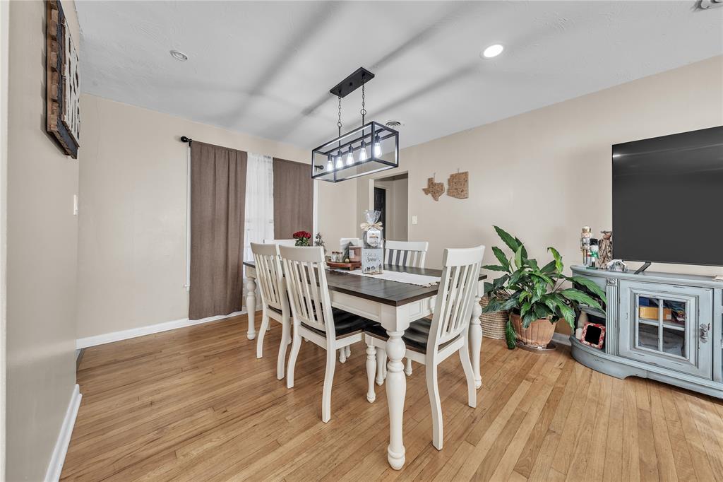 100 Rosedale Avenue Keene, TX 76059 - Photo 6 of 22 Dining area featuring wood-finish flooring, neutral wall paint, and a modern linear chandelier