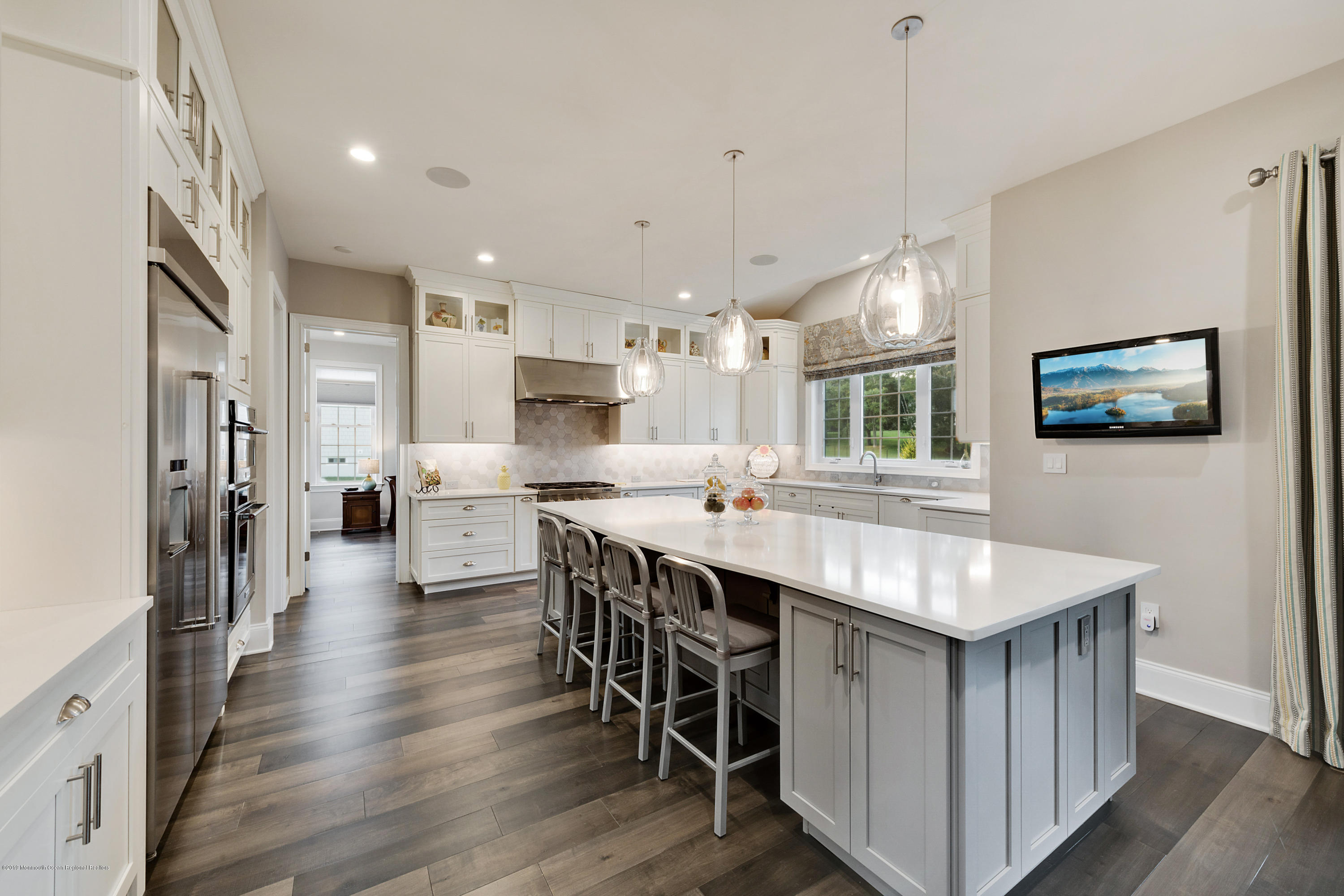 42 Windermere Road Lincroft, NJ 07738 - Photo 23 of 50 a kitchen with stainless steel appliances kitchen island granite countertop a table chairs sink refrigerator and cabinets