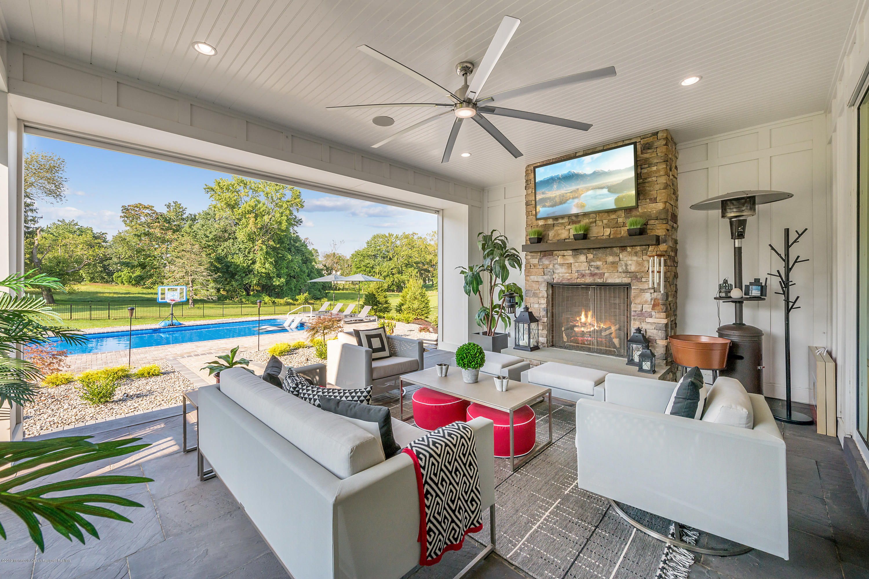 42 Windermere Road Lincroft, NJ 07738 - Photo 40 of 50 a living room with patio furniture and a fireplace
