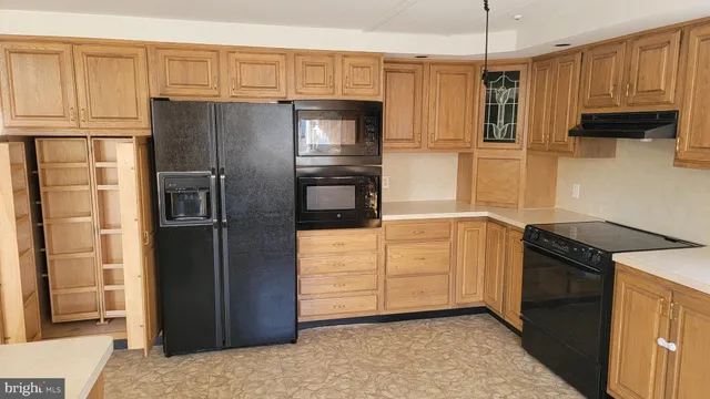 a kitchen with granite countertop a refrigerator stove and kitchen island