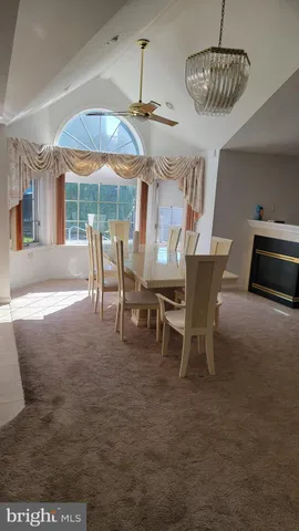 a dining room with furniture a chandelier and window