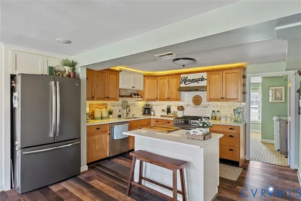 a kitchen with stainless steel appliances granite countertop a refrigerator and cabinets