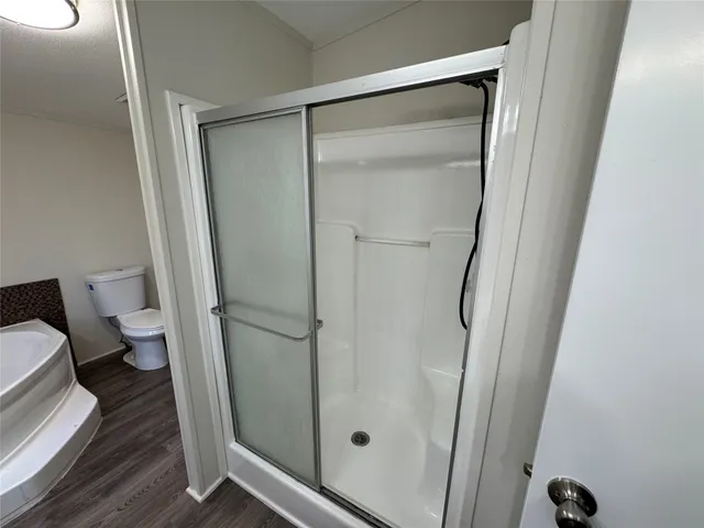 a bathroom with a glass door shower and toilet
