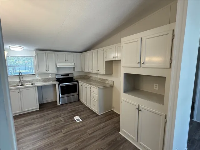 a kitchen with granite countertop white cabinets and white appliances