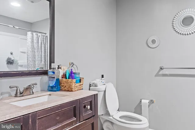 a bathroom with a sink vanity mirror and toilet