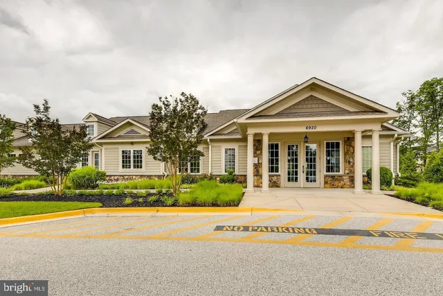 a view of a garden with a bench in front of house