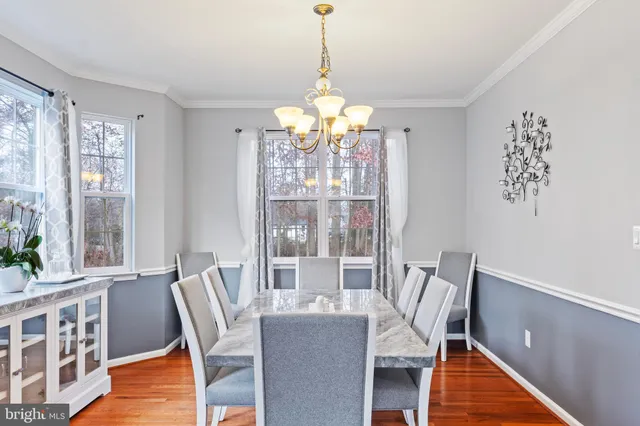 a view of a dining room with furniture wooden floor and chandelier