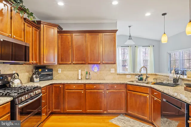 a kitchen with stainless steel appliances granite countertop a sink stove and cabinets