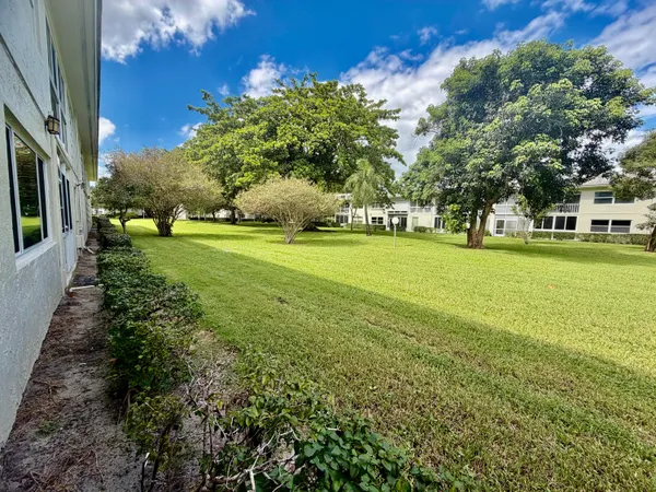 a bedroom with a bed a dresser and a large window