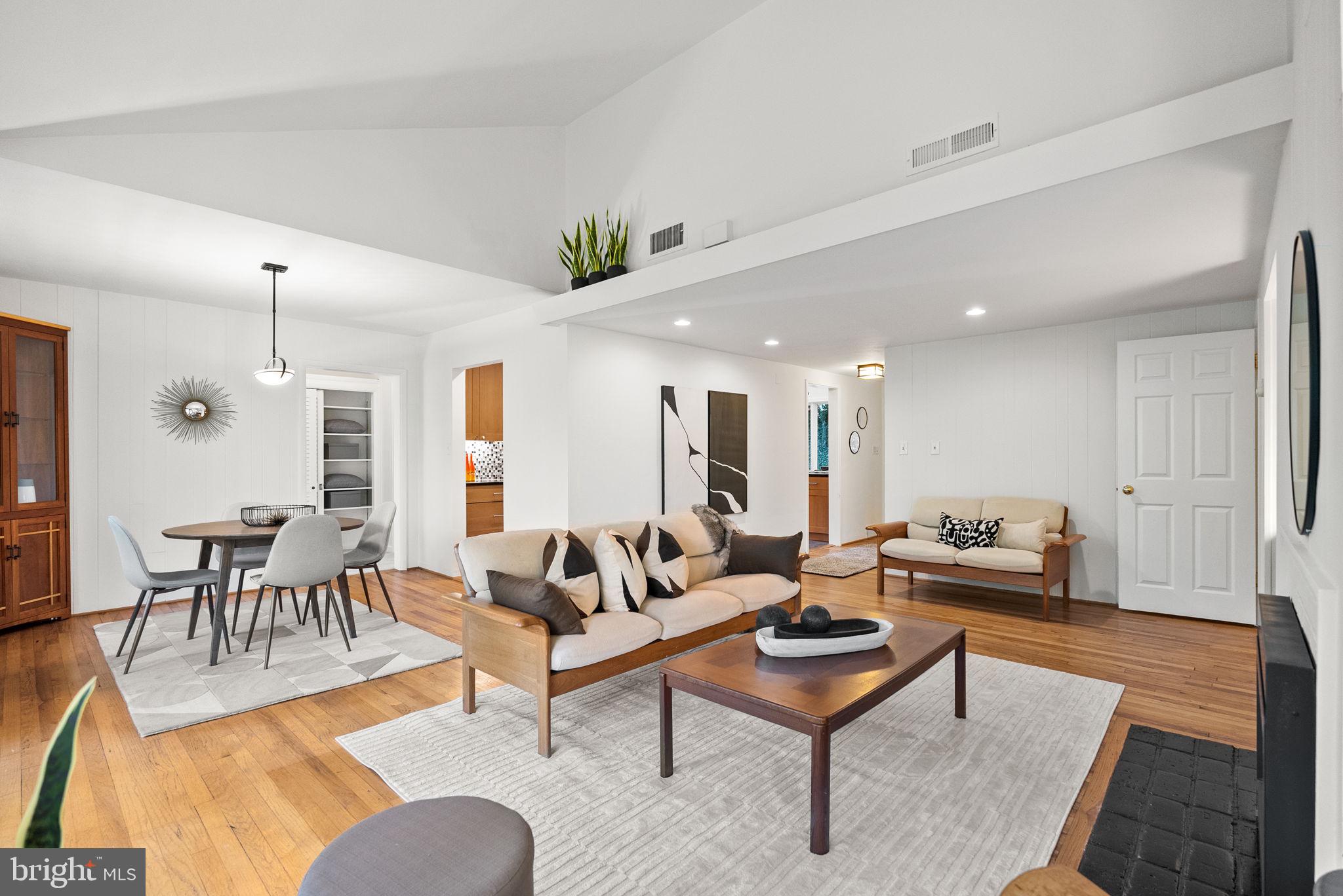 7111 Braeburn Place Bethesda, MD 20817 - Photo 11 of 86 a living room with furniture a rug and a dining table with wooden floor