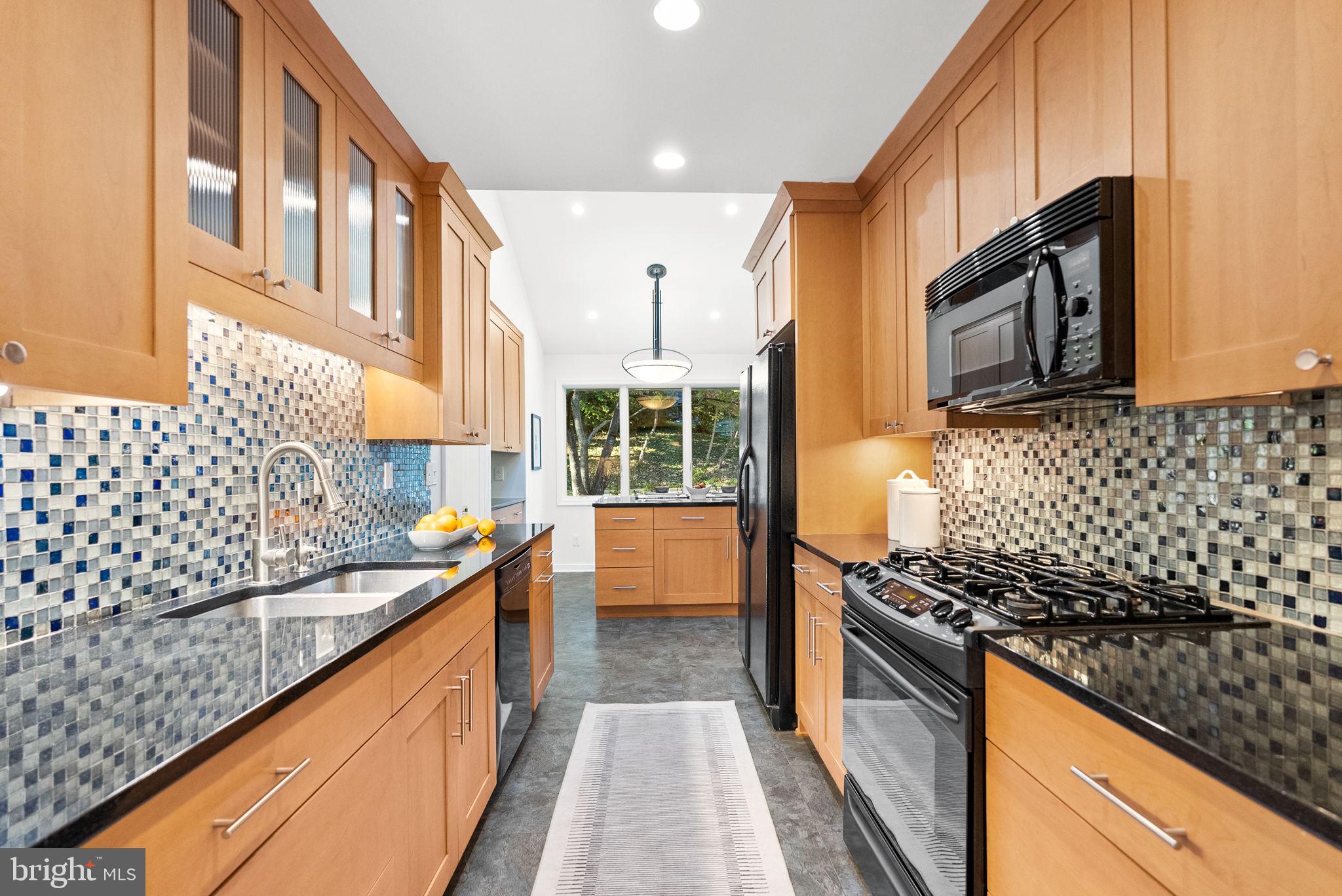 7111 Braeburn Place Bethesda, MD 20817 - Photo 16 of 86 a kitchen with stainless steel appliances a stove a sink and a microwave