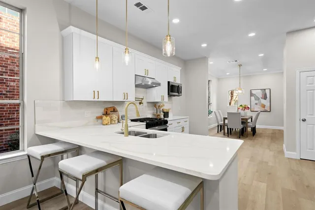 a kitchen with stainless steel appliances granite countertop a stove and a sink
