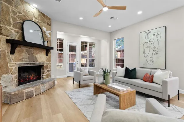 a living room with furniture a fireplace and a large window
