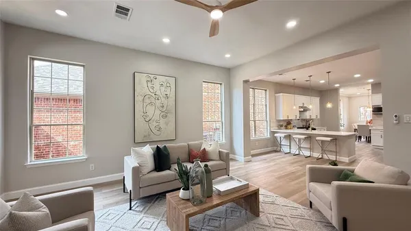 a living room with furniture a fireplace and a large window
