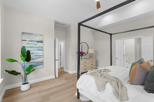 a bedroom with a bed and a potted plant