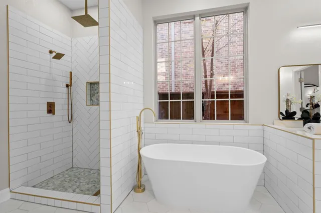 a bathroom with a double vanity sink a mirror and a bathtub