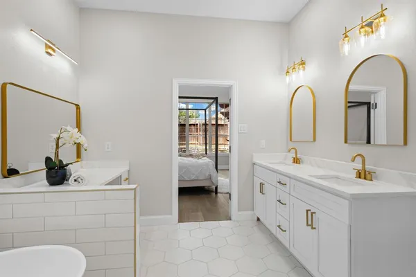 a bathroom with a double vanity sink a mirror and a bathtub