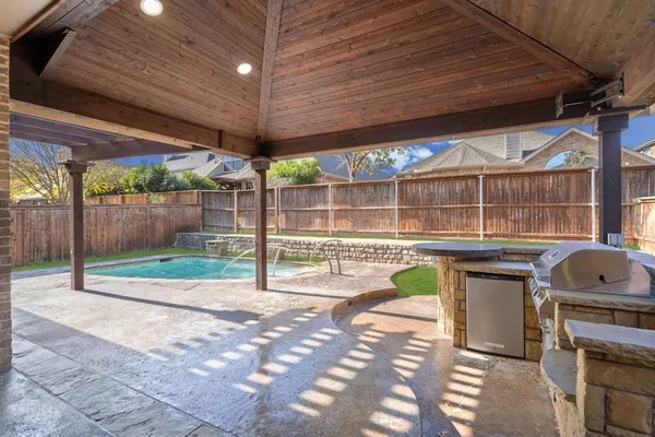 a open kitchen with stainless steel appliances granite countertop a stove kitchen island a sink dishwasher and granite countertops with a flat screen tv