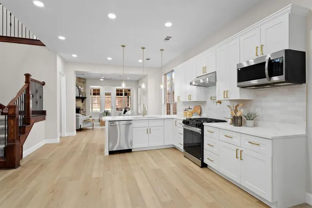a large kitchen with stainless steel appliances lots of counter space sink refrigerator and cabinets