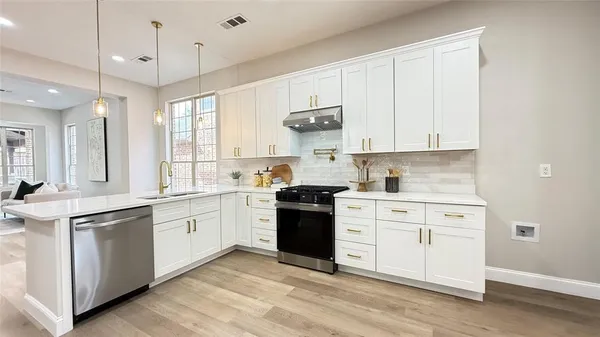 a kitchen with granite countertop a sink appliances cabinets and furniture