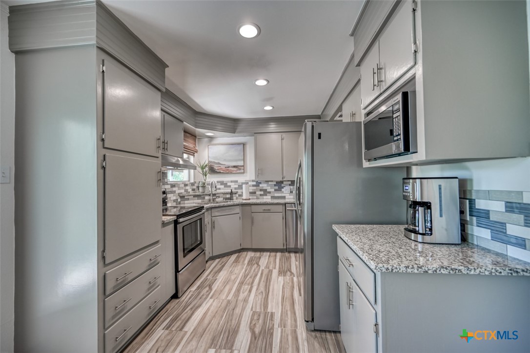 644 Cypress Ridge Road McQueeney, TX 78123 - Photo 17 of 45 a kitchen with granite countertop stainless steel appliances cabinets a sink and a counter top space