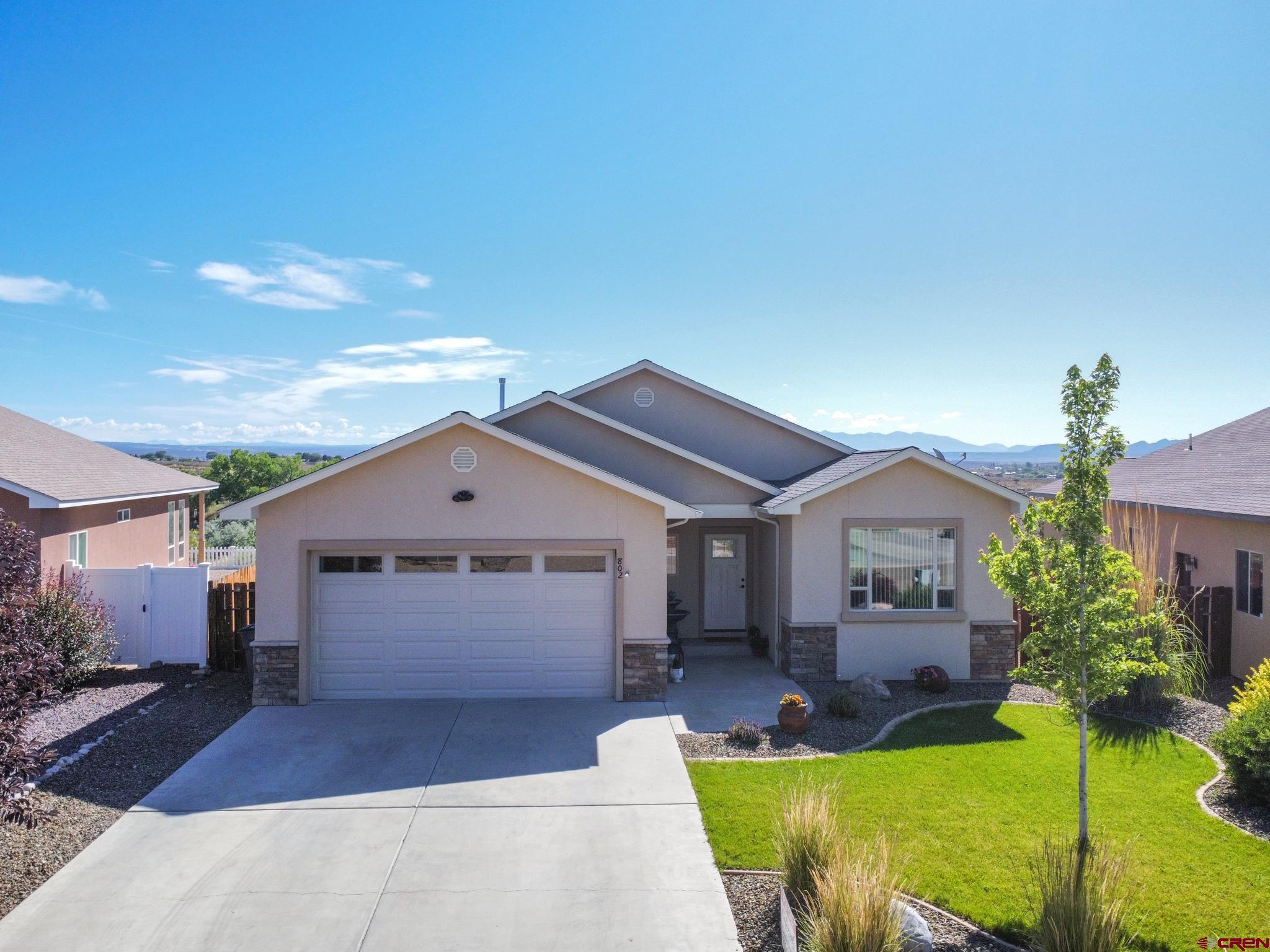 802 L Way Cortez, CO 81321 - Photo 2 of 21 a view of a house with a big yard potted plants and large tree
