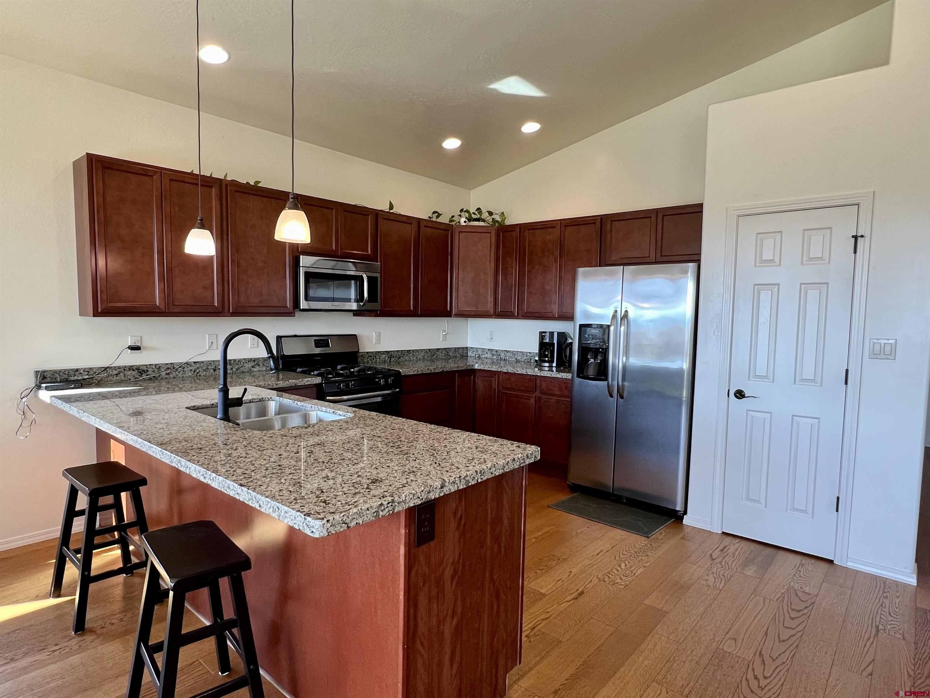 802 L Way Cortez, CO 81321 - Photo 4 of 21 a kitchen with stainless steel appliances granite countertop a sink refrigerator and cabinets
