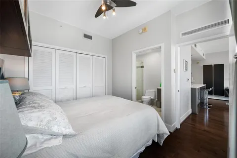 a bedroom with a bed and a flat tv screen on dresser