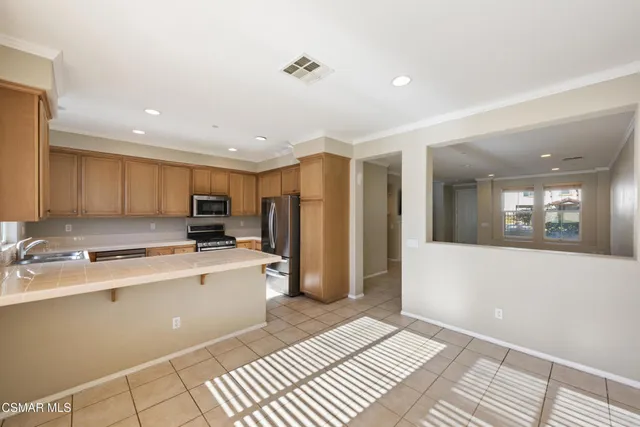 a view of a kitchen with a sink and dishwasher with wooden floor