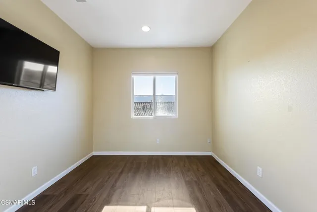 a view of a room with wooden floor and a window