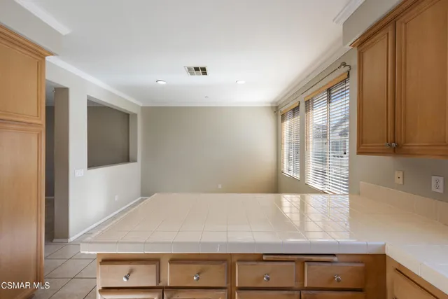 a view of kitchen with granite countertop cabinets and window