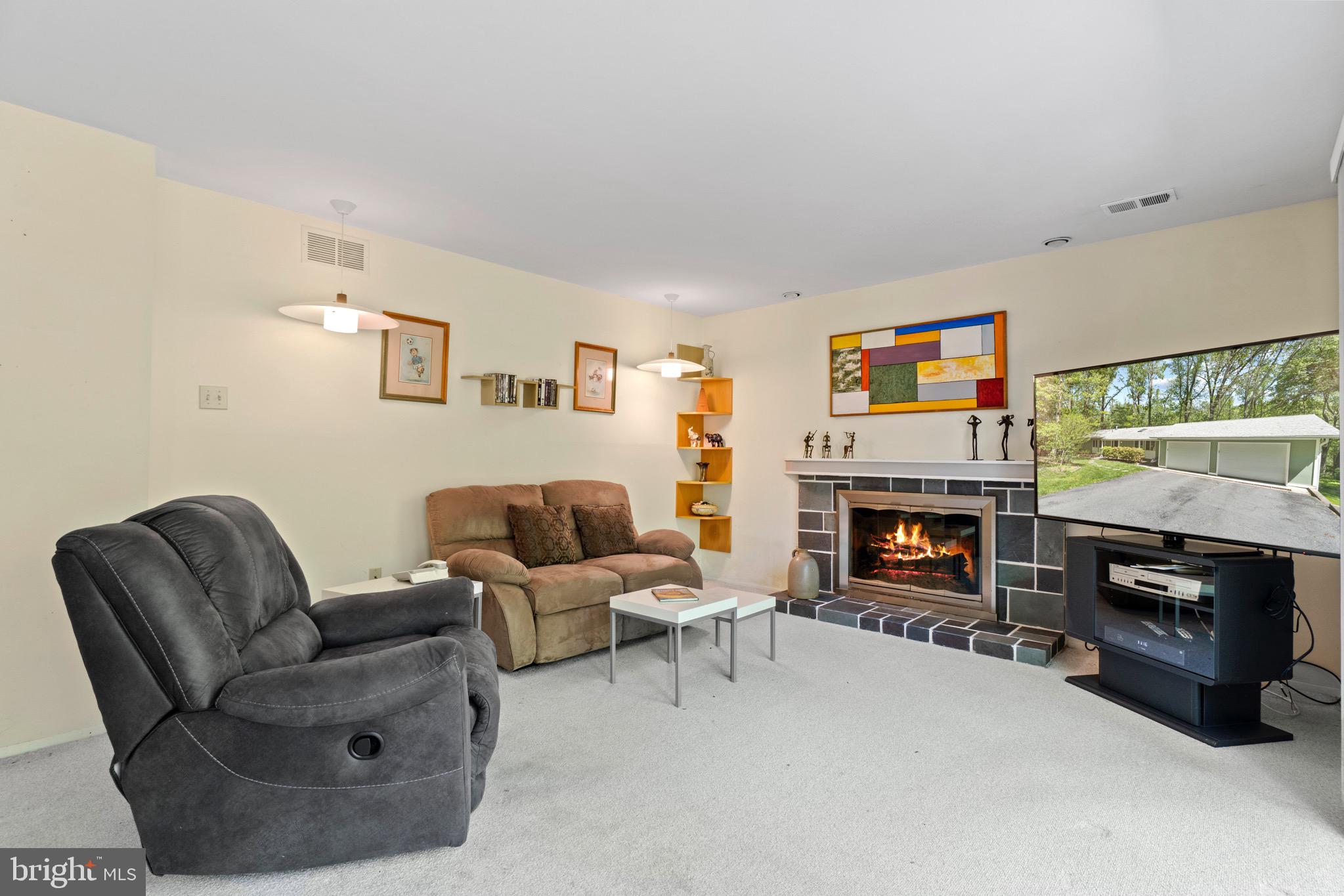 11318 Myrtle Lane Reston, VA 20191 - Photo 33 of 40 a living room with furniture a flat screen tv and a fireplace