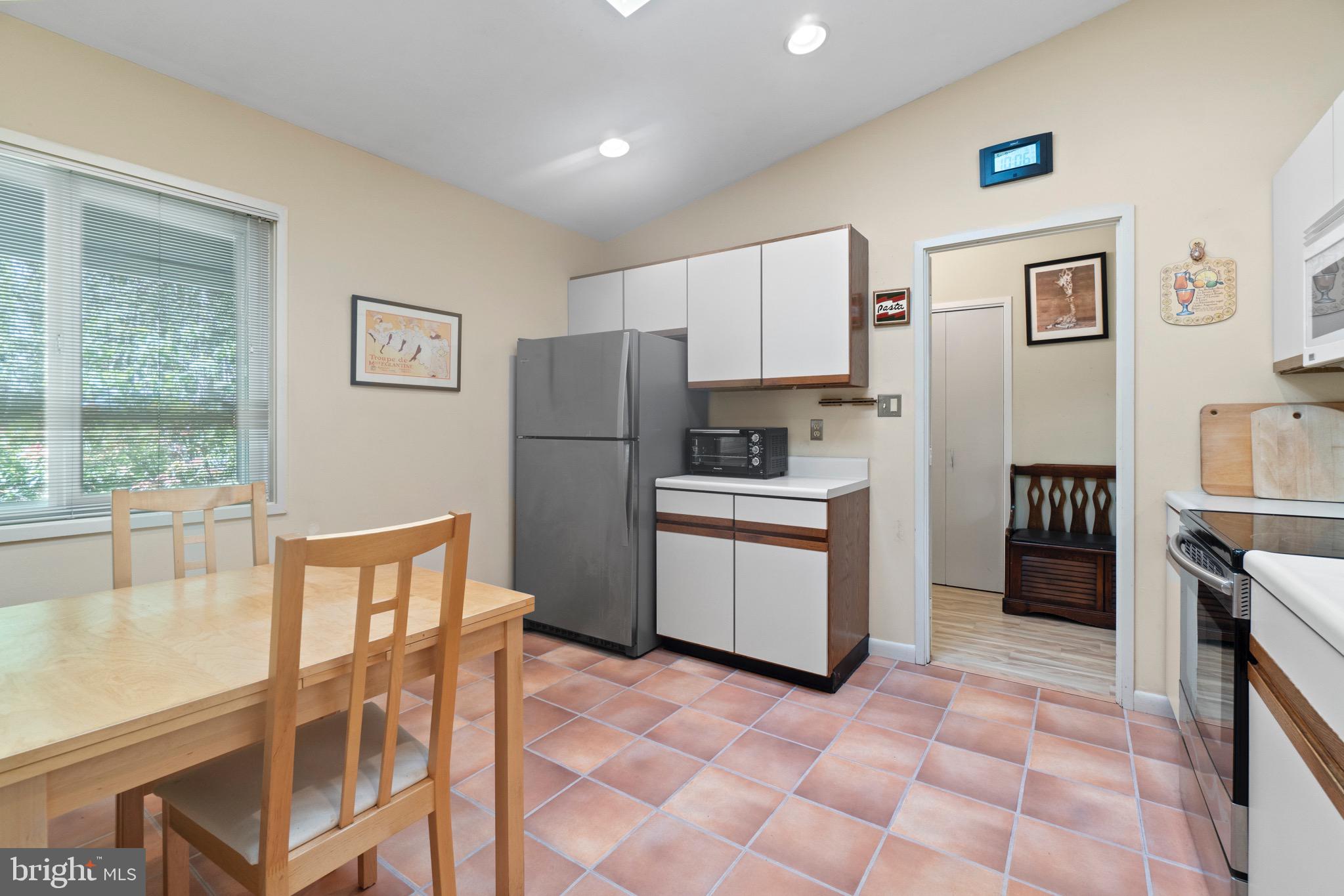 11318 Myrtle Lane Reston, VA 20191 - Photo 9 of 40 a kitchen with a refrigerator a stove top oven and a dining table