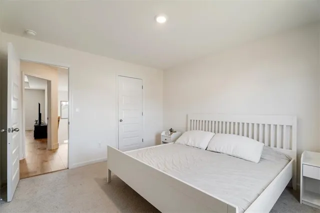 a bedroom with a bed and painting on the wall