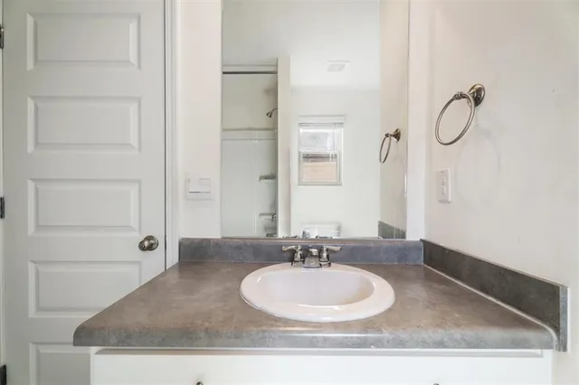 a bathroom with a granite countertop sink mirror and vanity