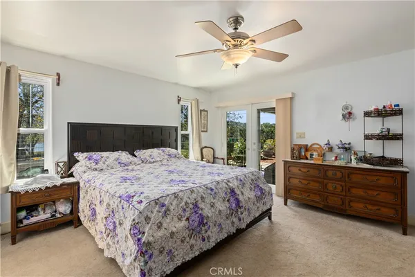 a bedroom with a bed chandelier and a window