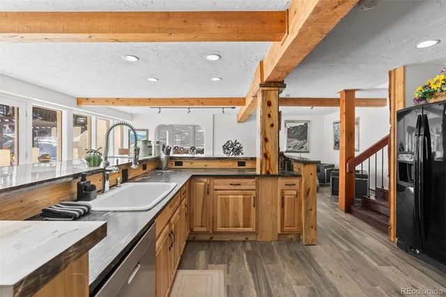 a kitchen with stainless steel appliances kitchen island granite countertop a stove a sink and a refrigerator