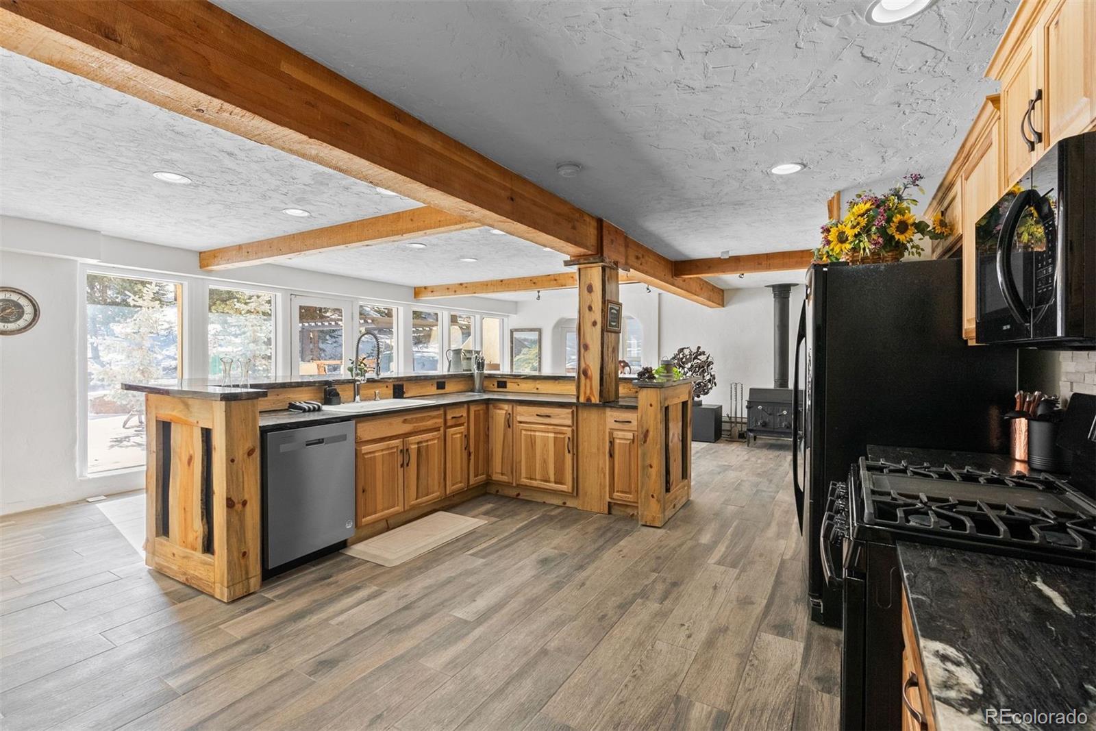 Hotel Way Evergreen, CO 80439 - Photo 31 of 50 a kitchen with stainless steel appliances kitchen island granite countertop a stove a sink and a refrigerator