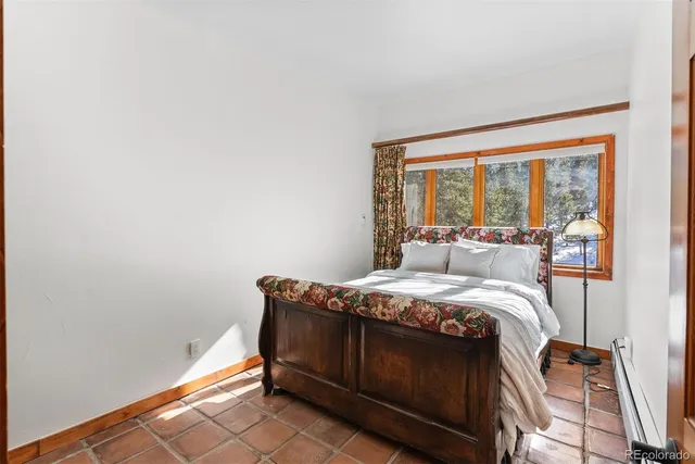 a bedroom with two beds and wooden floor