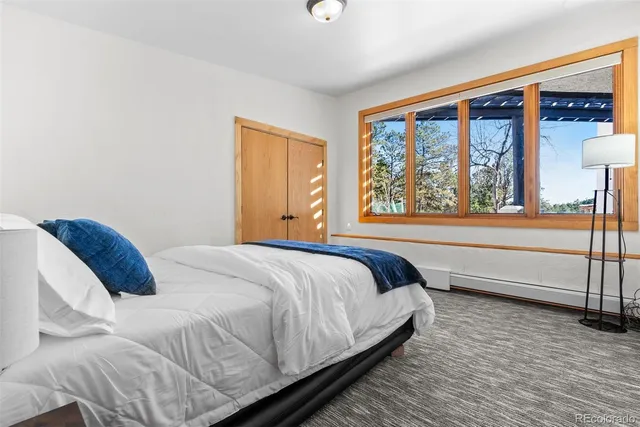 a bedroom with a bed and a large window