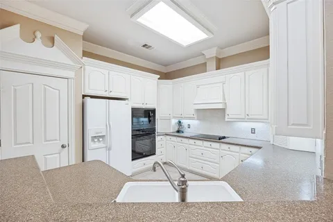 a kitchen with stainless steel appliances kitchen island granite countertop a refrigerator and cabinets