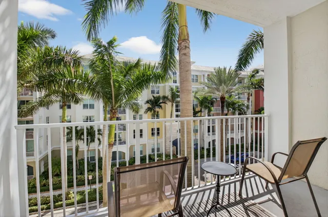 front view of a house with a yard and palm trees
