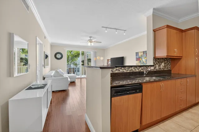 a kitchen with stainless steel appliances granite countertop a refrigerator a stove a sink dishwasher and wooden cabinets with wooden floor